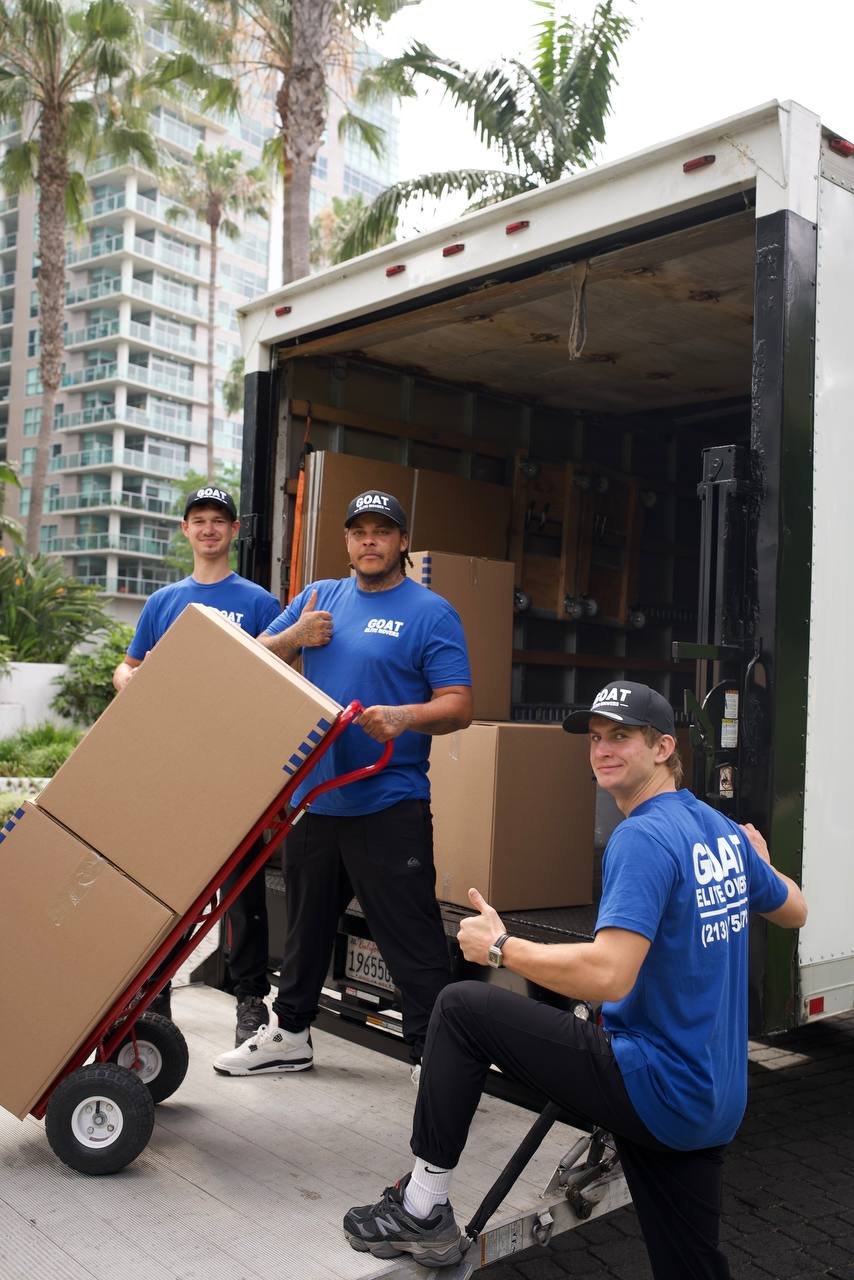 GOAT movers wheeling boxes into the truck on a dolly