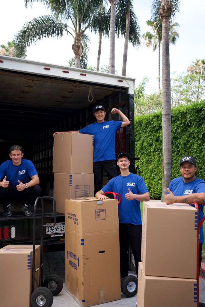 Crew with hand trucks and stacks of boxes