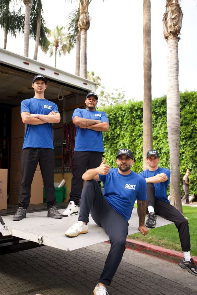 GOAT Elite Movers crew posing in front of the truck